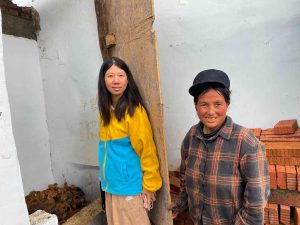 Program coordinator and beneficiary pose for a photo with the chicks