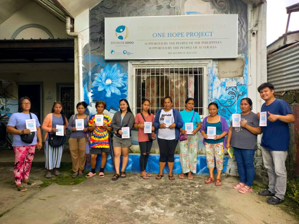 Filipino microfinance staff and beneficiaries holding activity booklets.