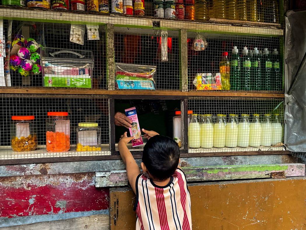 Child buying from a small variety store in the Philippines