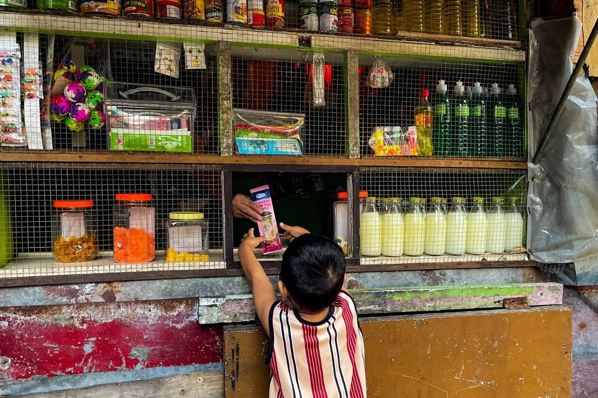 Child buying from a small variety store in the Philippines