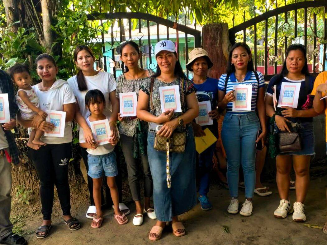 Filipino microfinance staff and beneficiaries holding activity booklets.