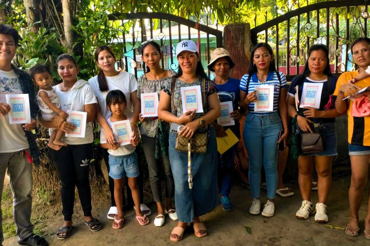 Filipino microfinance staff and beneficiaries holding activity booklets.