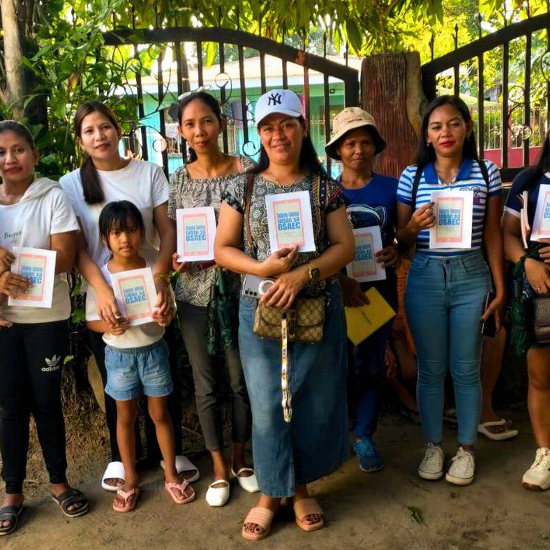 Filipino microfinance staff and beneficiaries holding activity booklets.