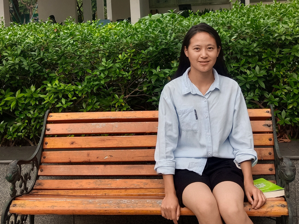 Chinese teenage girl sitting on a bench.