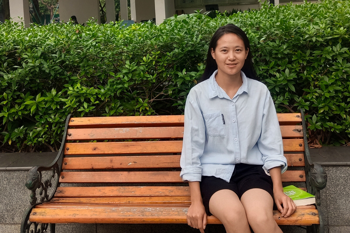 Chinese teenage girl sitting on a bench.