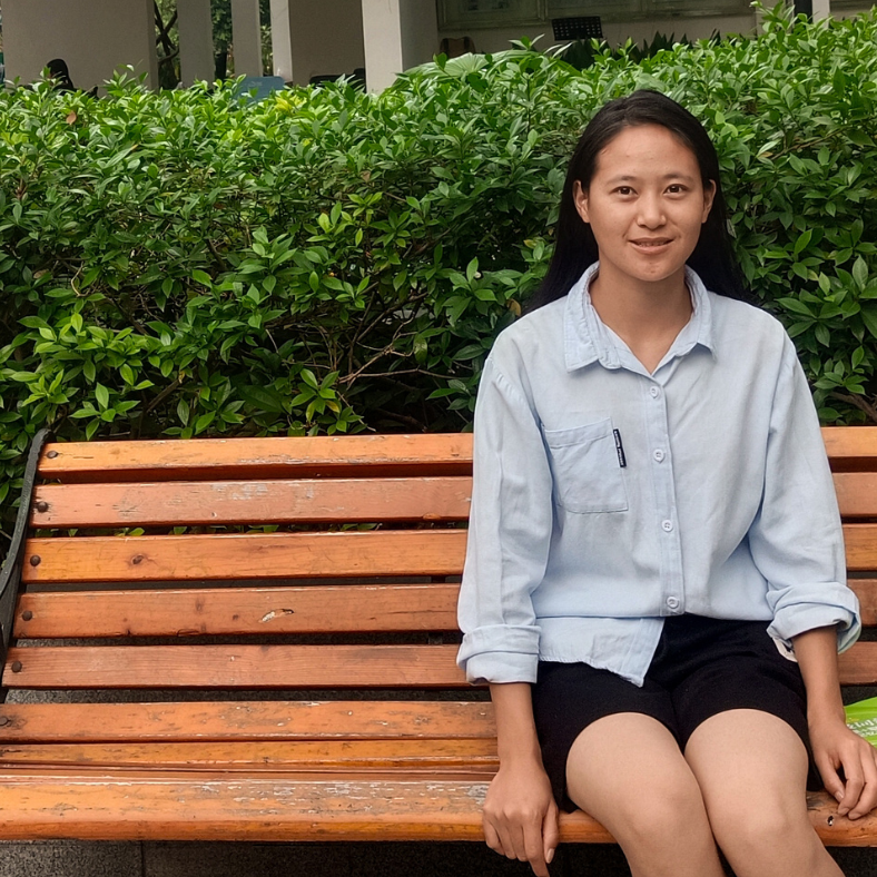 Chinese teenage girl sitting on a bench.