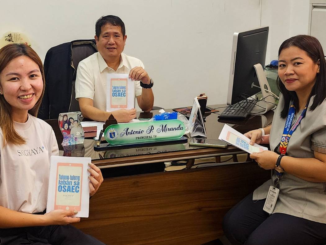 Staff and school leaders posing with activity booklets