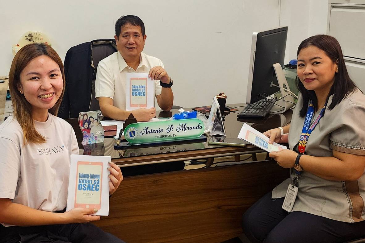 Staff and school leaders posing with activity booklets