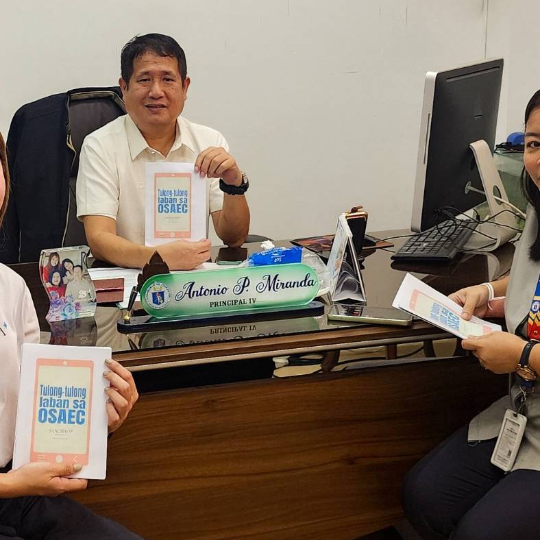 Staff and school leaders posing with activity booklets