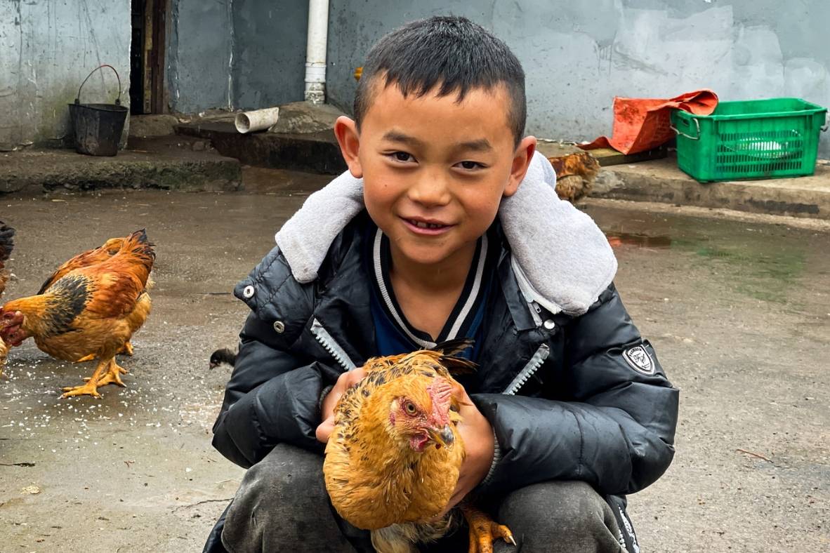 Beneficiary's son holding a chicken