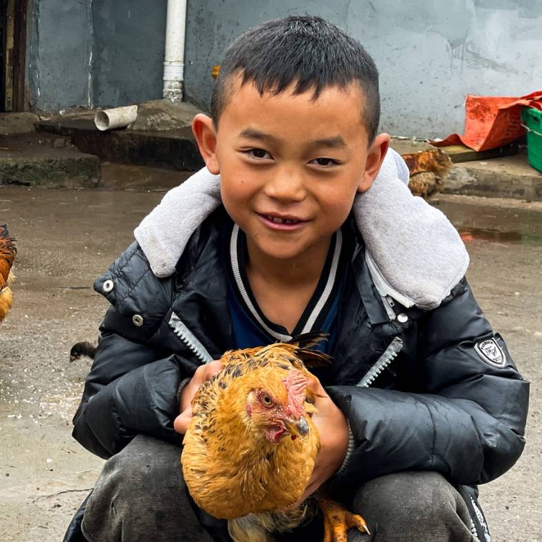 Beneficiary's son holding a chicken