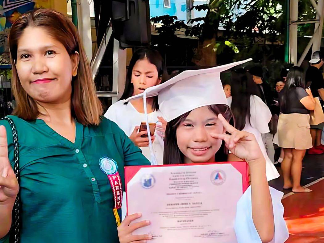 Mother and daughter at the daughter's elementary school graduation ceremony