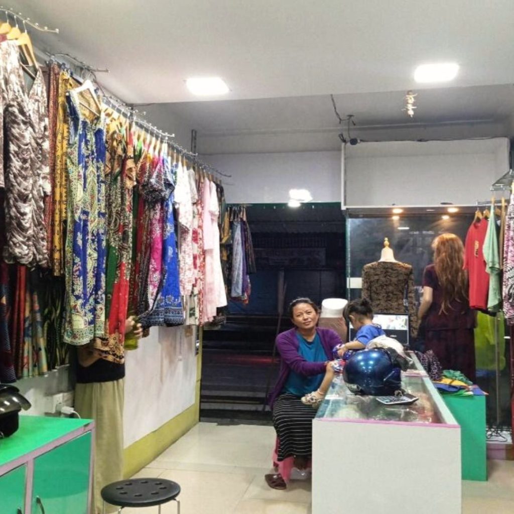 Nepali woman sitting in her clothing store