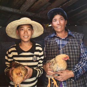 Chinese woman and her son holding chickens