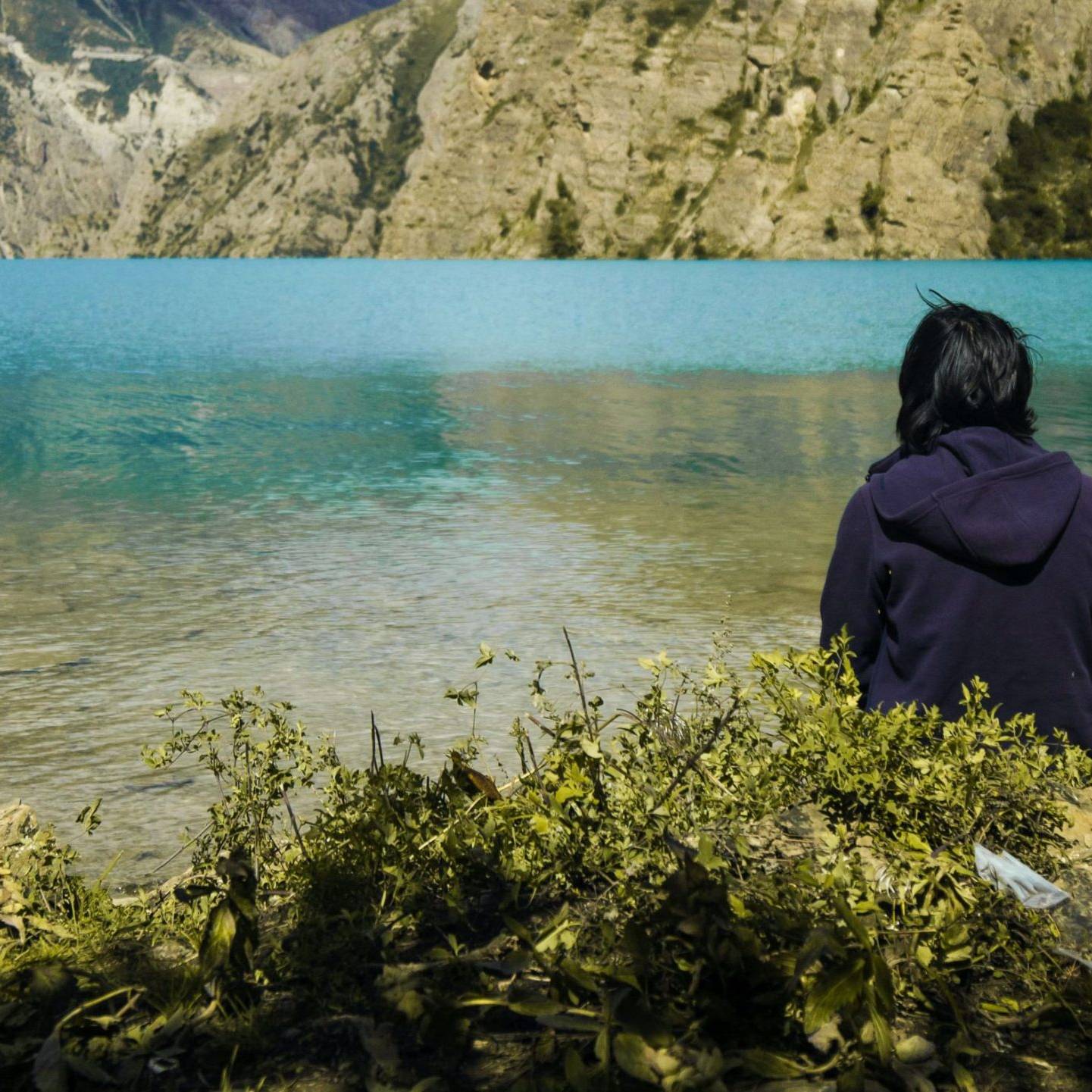 Woman sitting in front of a lake.