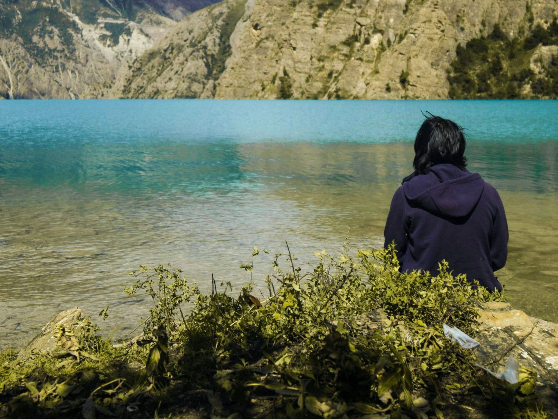 Woman sitting in front of a lake.