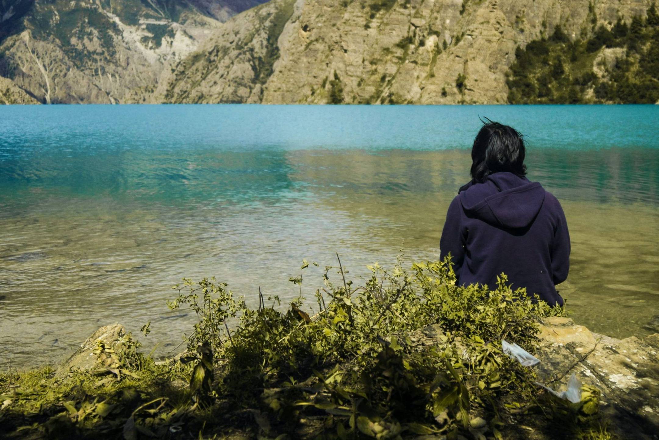 Woman sitting in front of a lake.