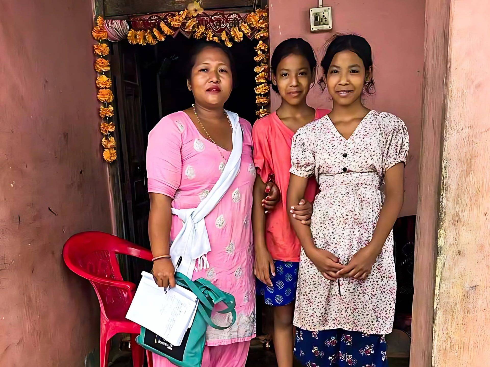 Woman posing with teenage twin girls