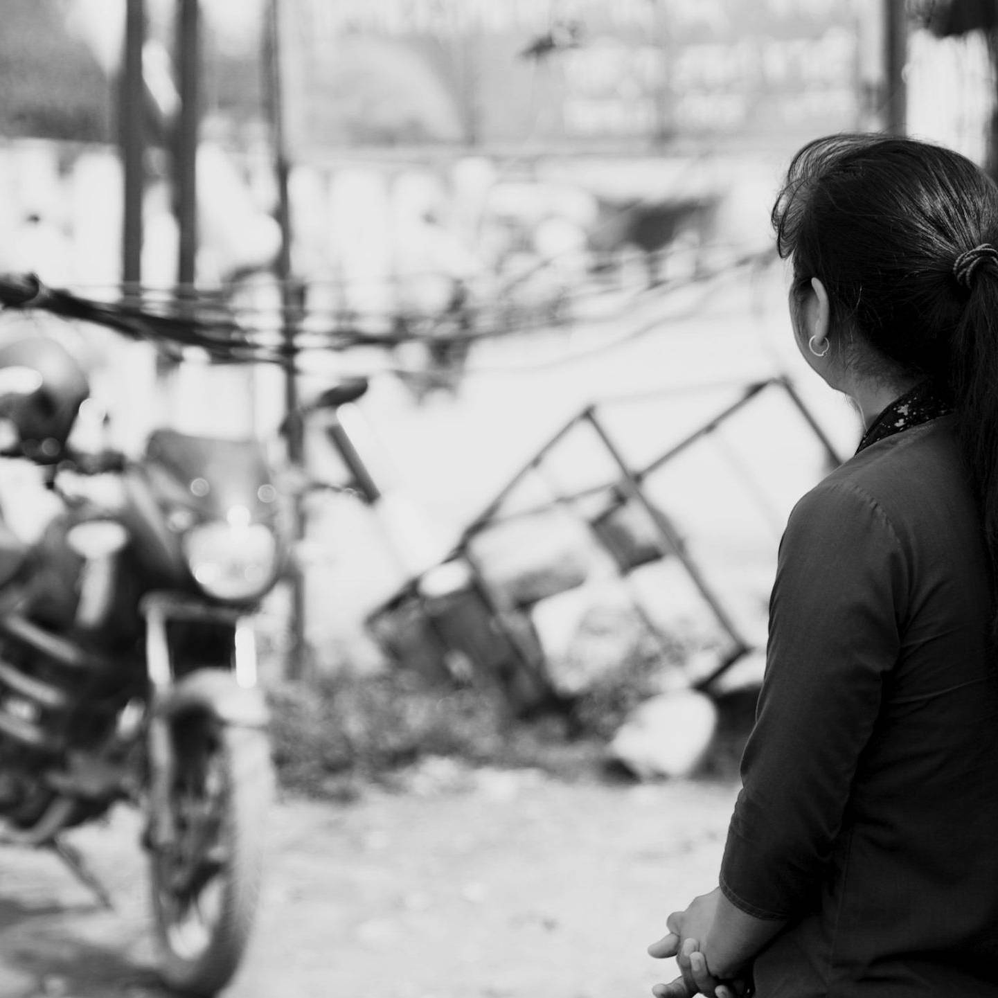 Girl looking at the distance with a motorcycle in the background