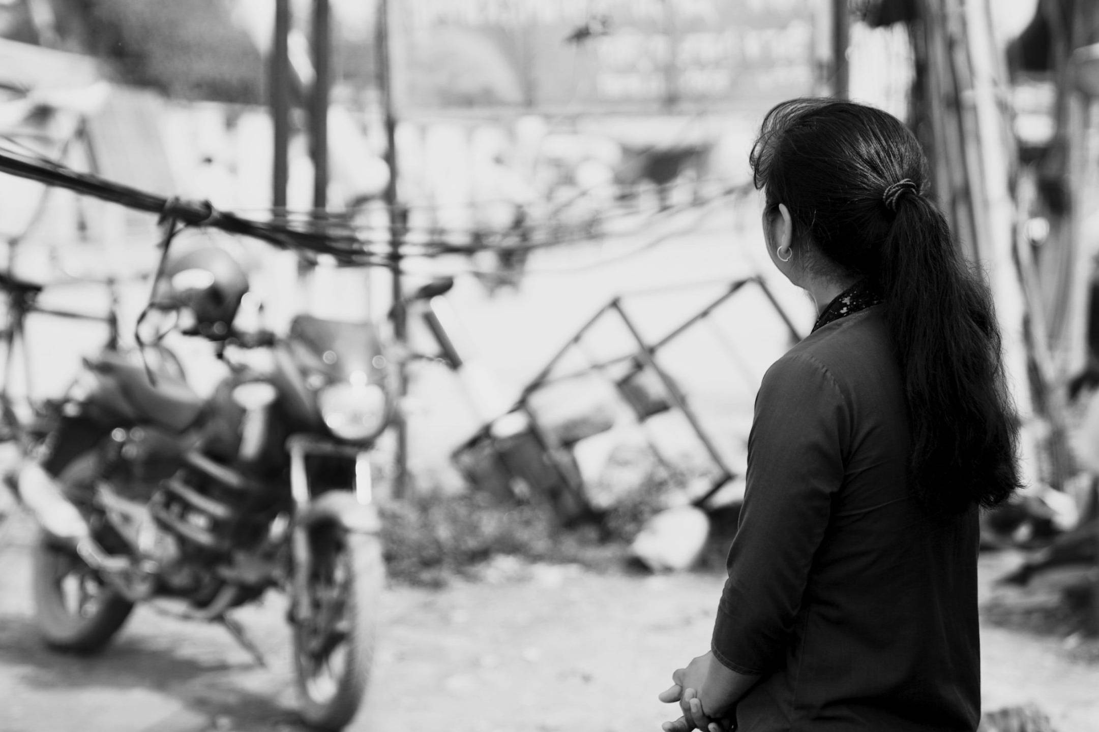 Girl looking at the distance with a motorcycle in the background