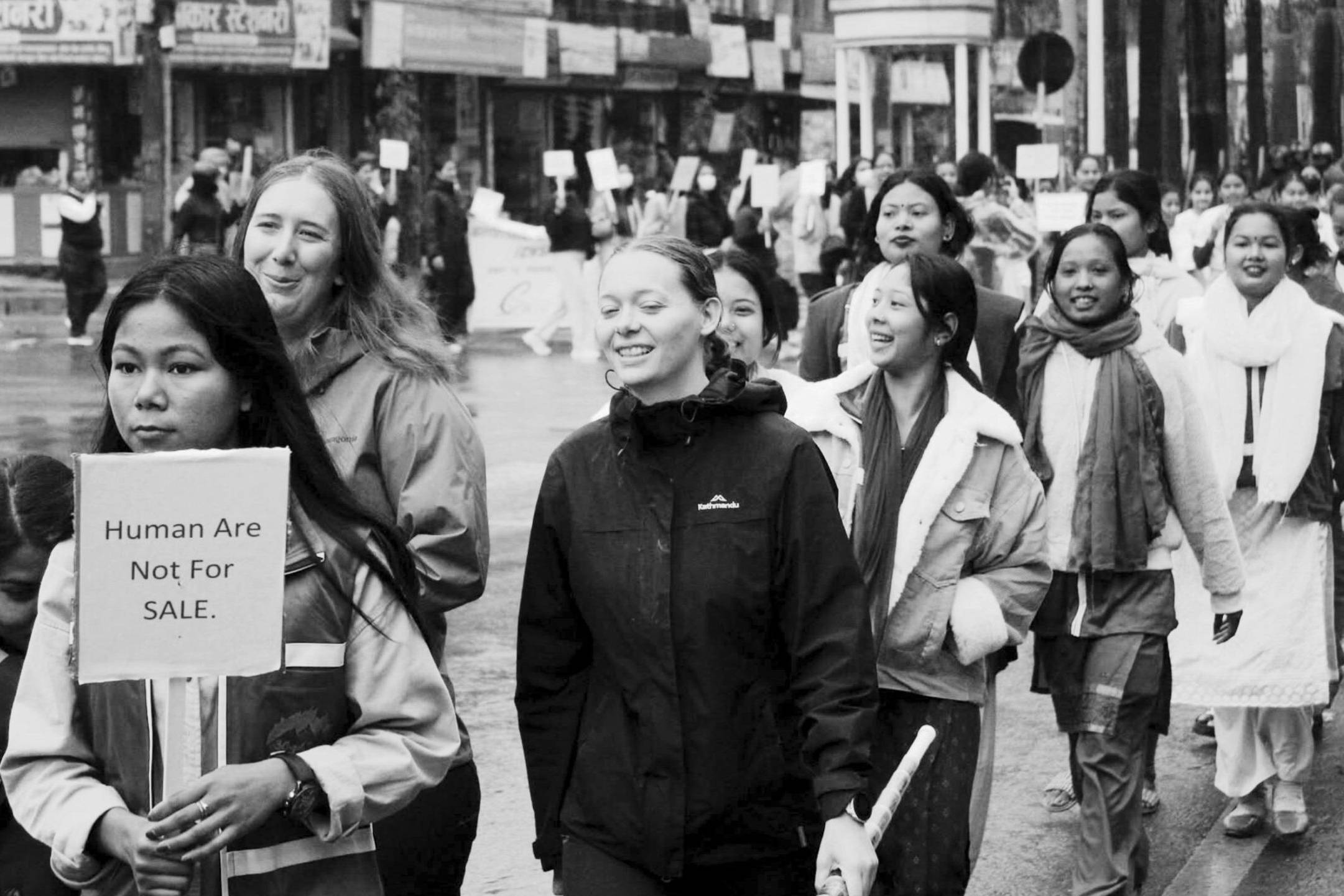 A diverse group of women walking together on a street, proudly holding signs advocating for their cause.