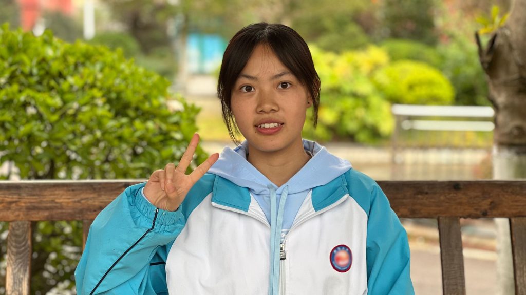 Chinese teenage girl doing a peace sign