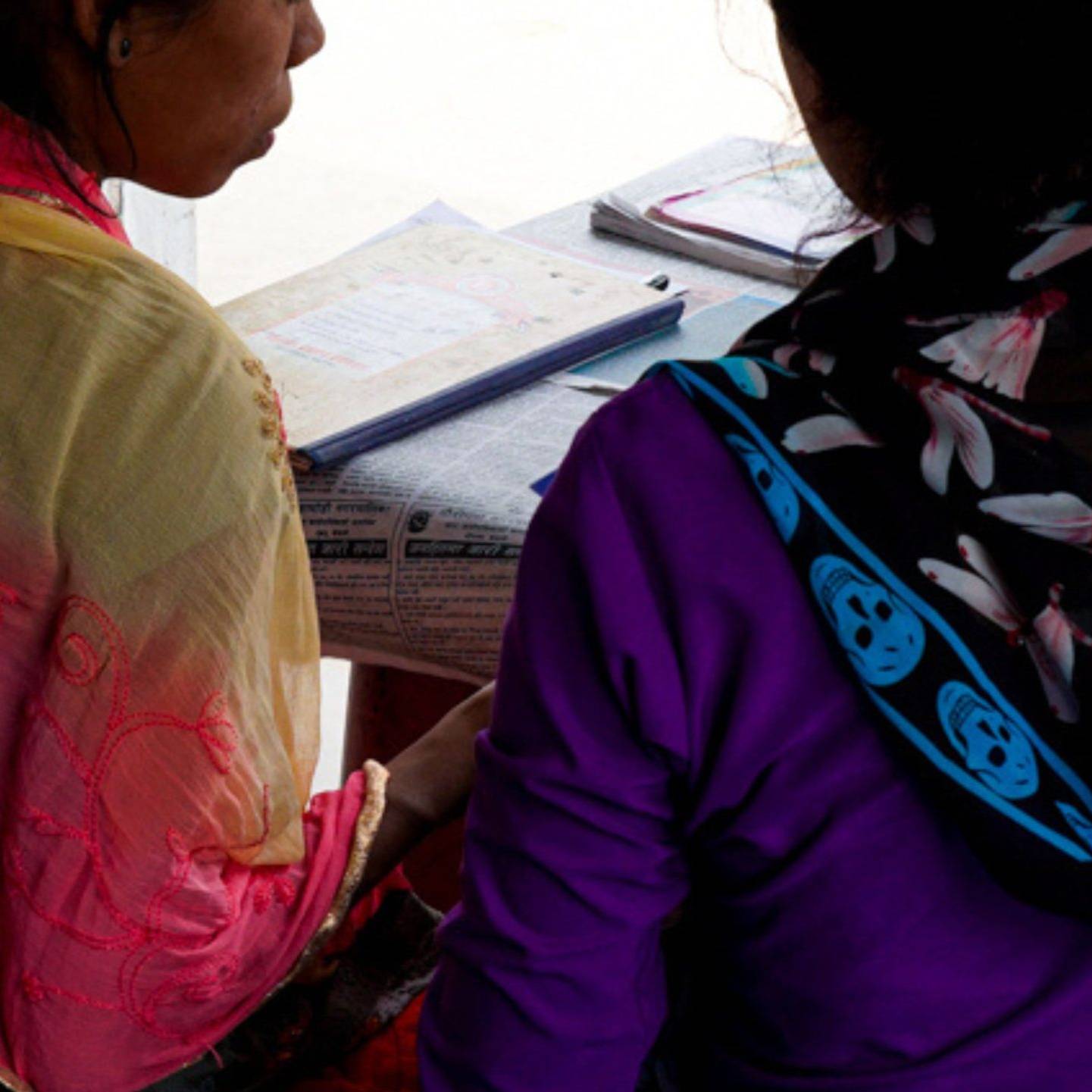 Nepali woman being oriented by another woman