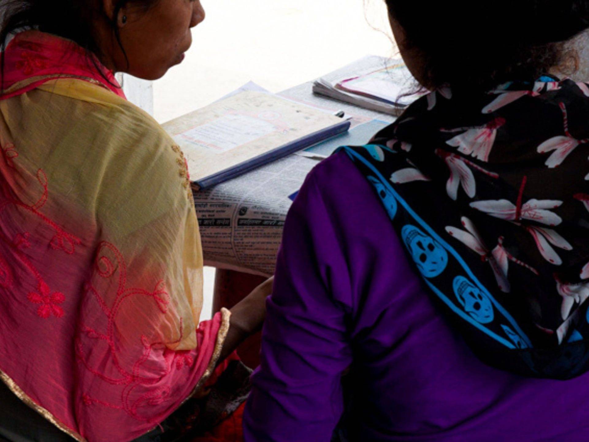 Nepali woman being oriented by another woman