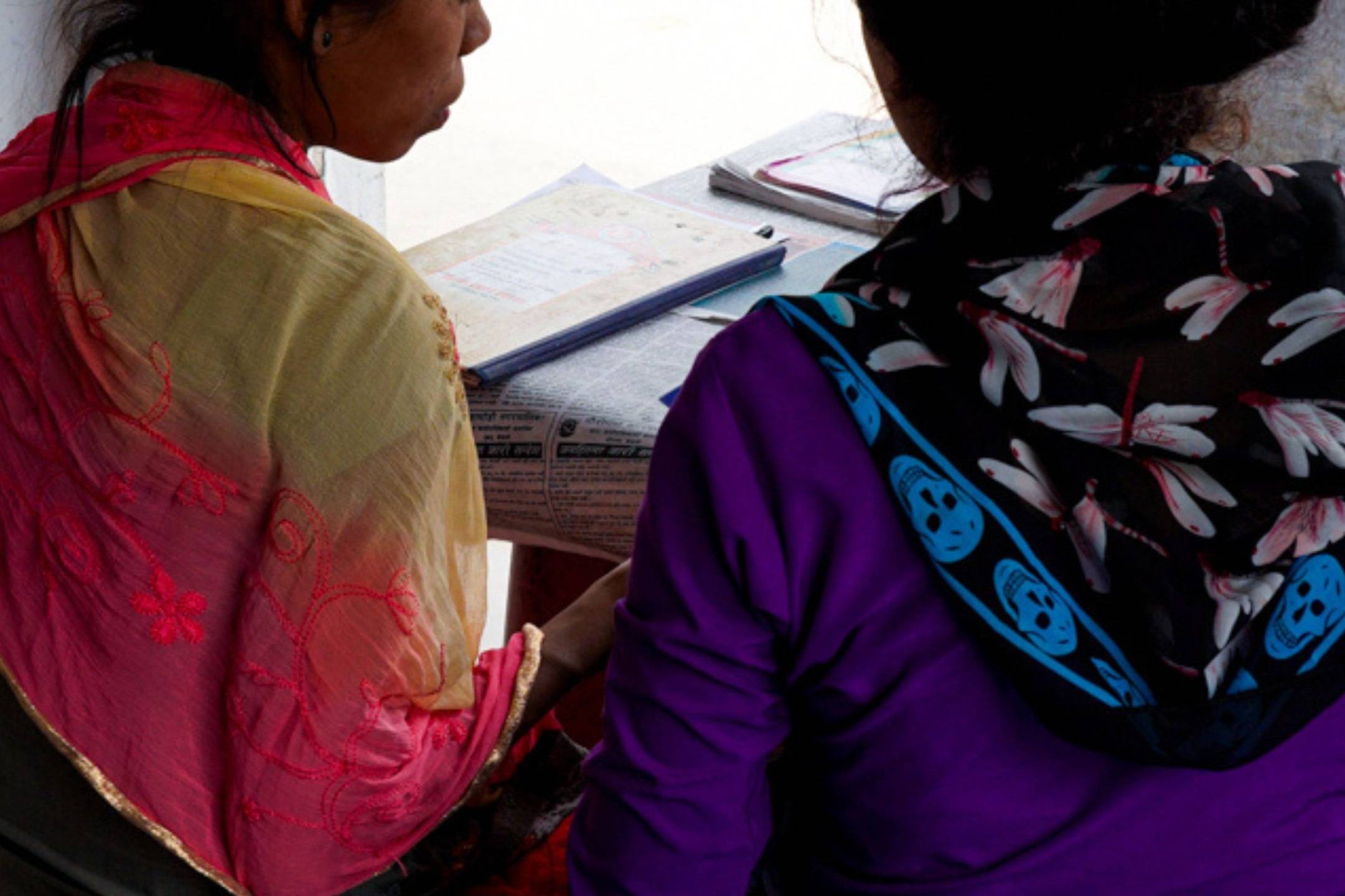 Nepali woman being oriented by another woman