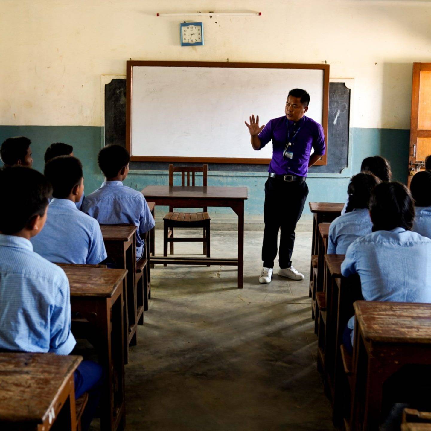 A class of Nepali students listening to a man in front.