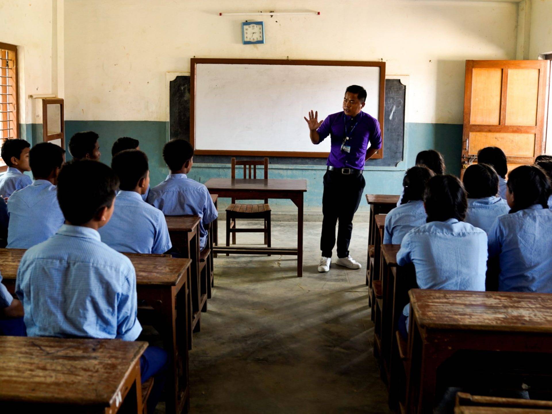 A class of Nepali students listening to a man in front.