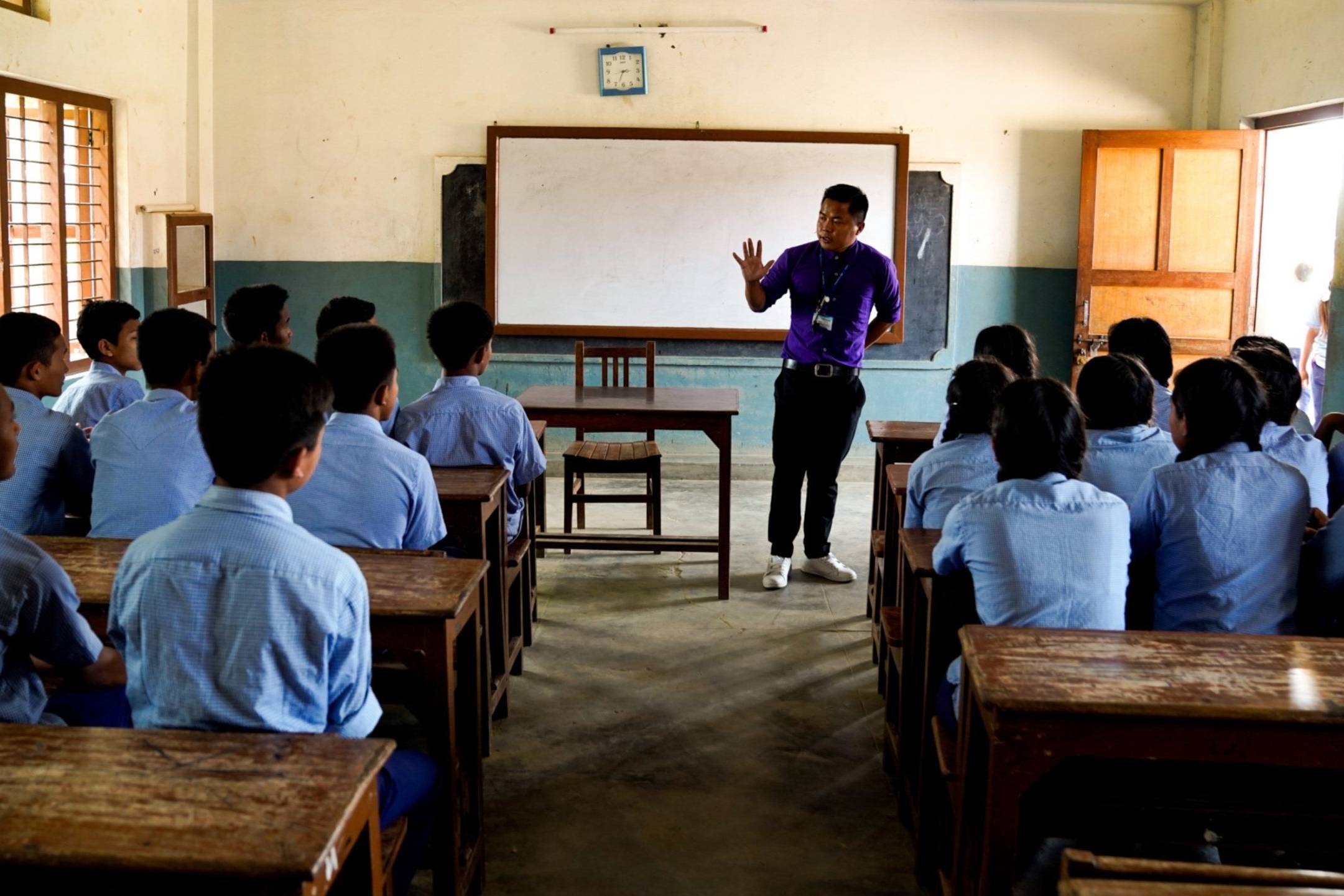 A class of Nepali students listening to a man in front.