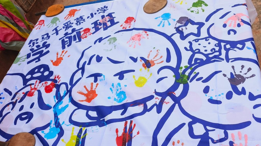 White cloth with cartoons and handprints painted on it