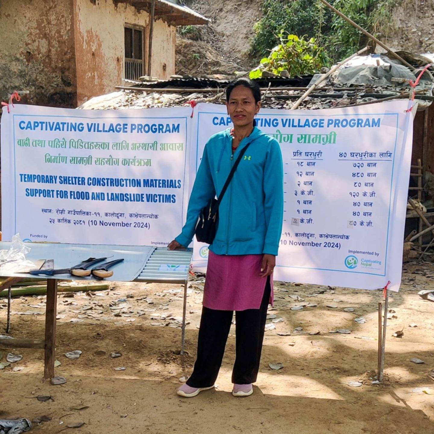 A woman in an outdoor setting poses beside a table in front of a sign.
