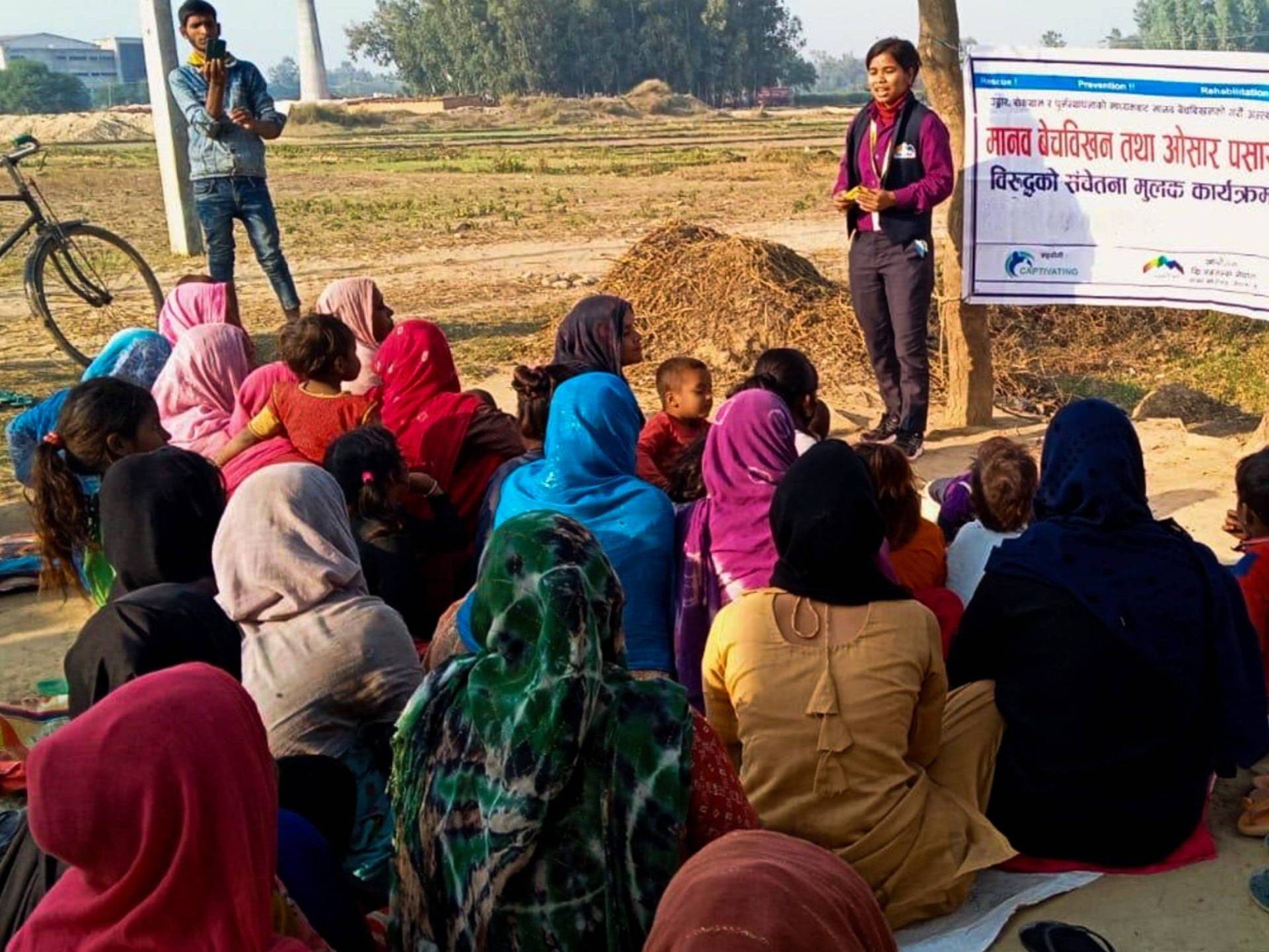 A diverse group of people on the ground, displaying a poster, actively participating in a community event.