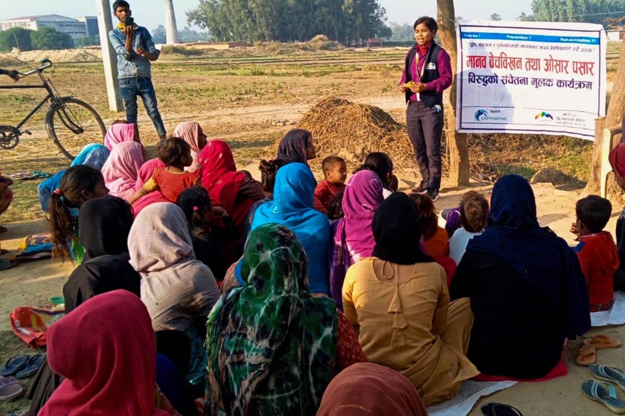 A diverse group of people on the ground, displaying a poster, actively participating in a community event.