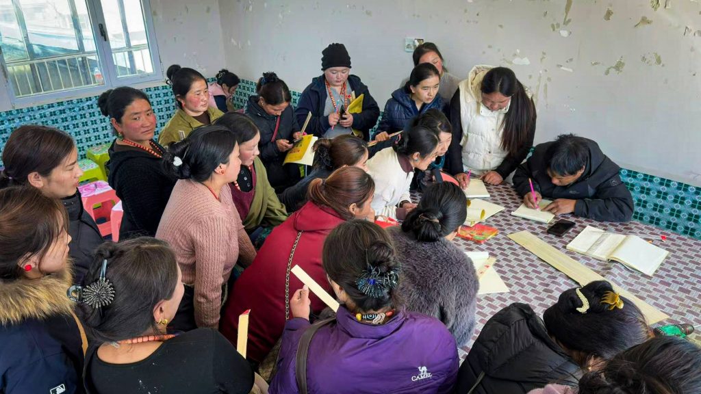 A diverse group of women around a table, actively participating and listening to the male trainer.