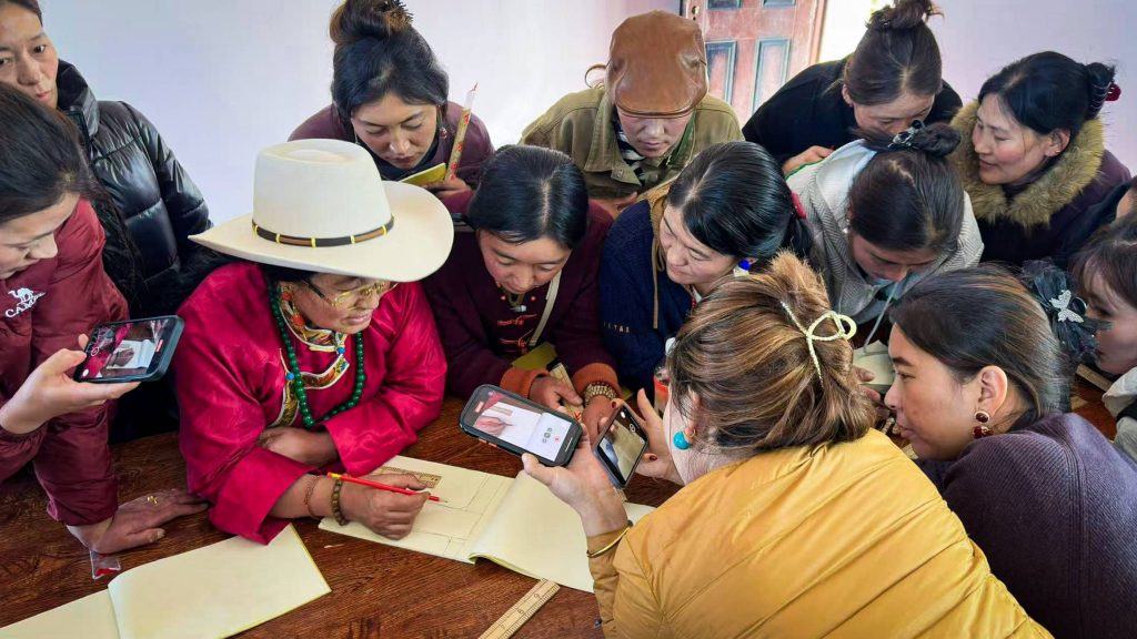 Several women gather at a table, actively writing notes, taking pictures with their phone, and sharing ideas with a pen and paper.