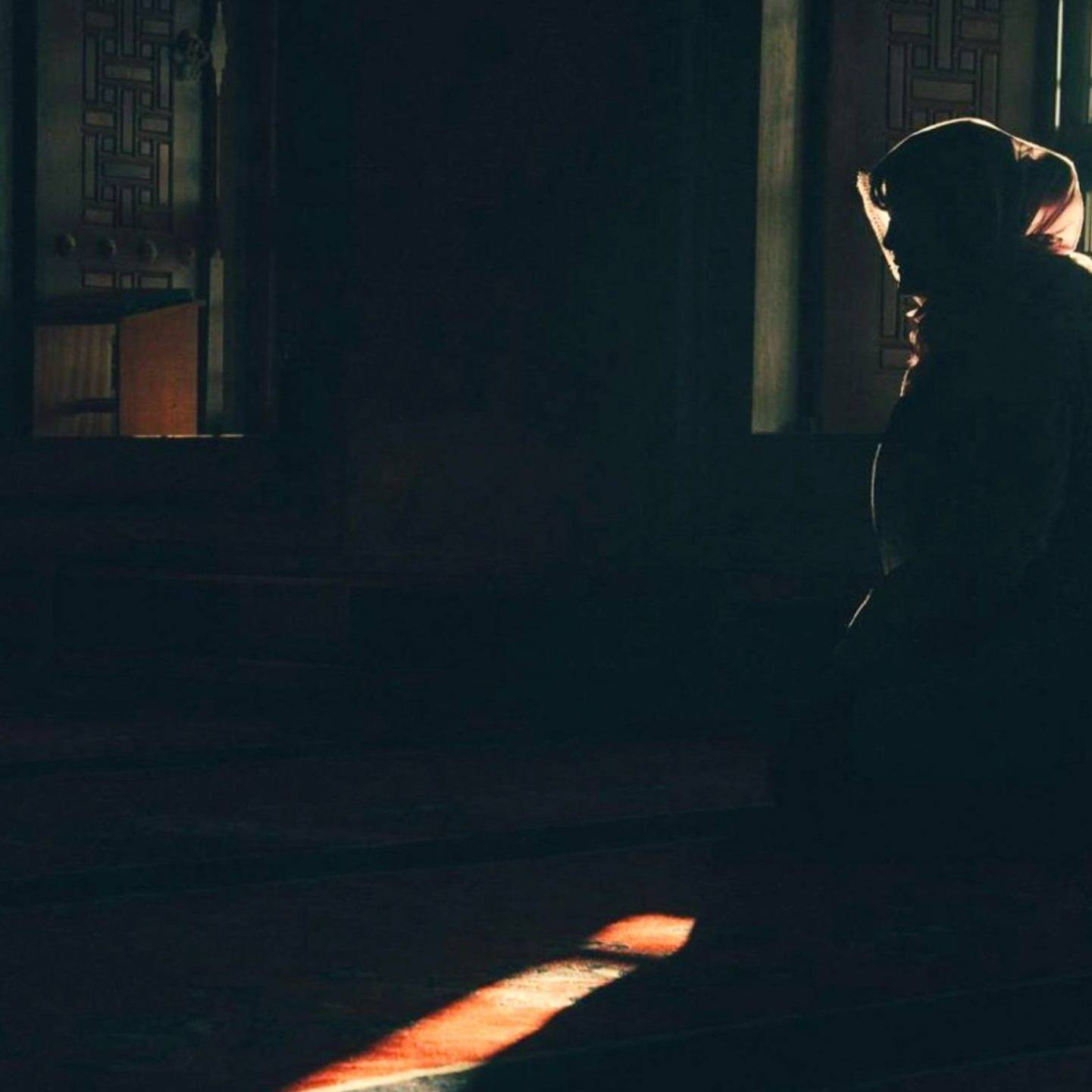 Silhouette of a woman in front of a large window, light streaming in around her.