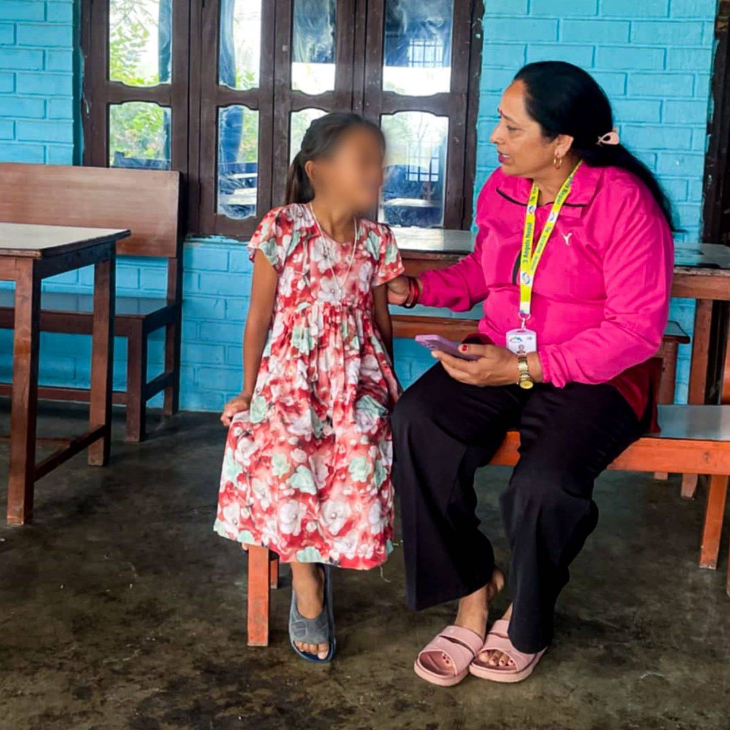 A woman and a child are seated together on a bench.