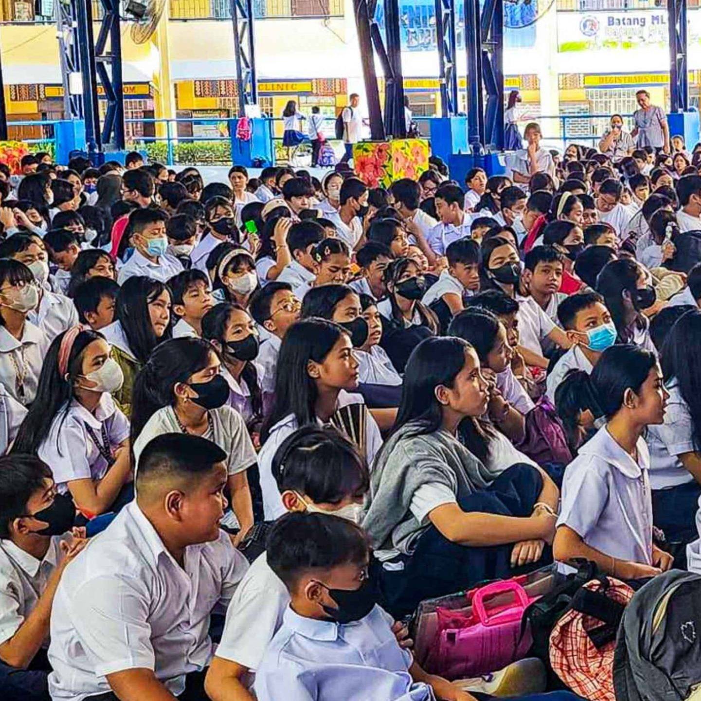 A diverse group of students sitting together in a school setting.