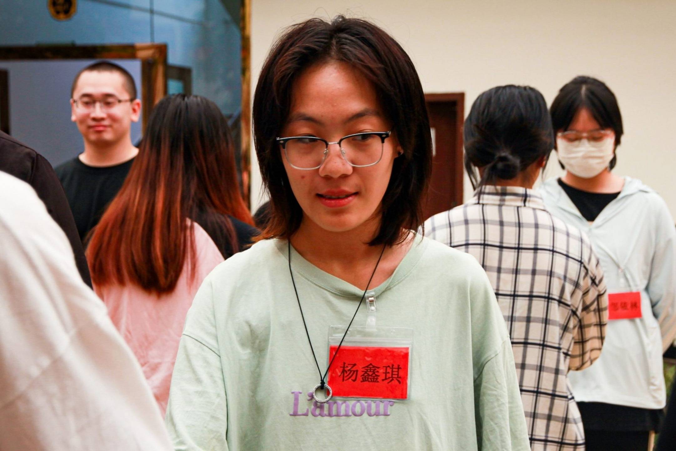 A woman with glasses wearing a green shirt, smiling.