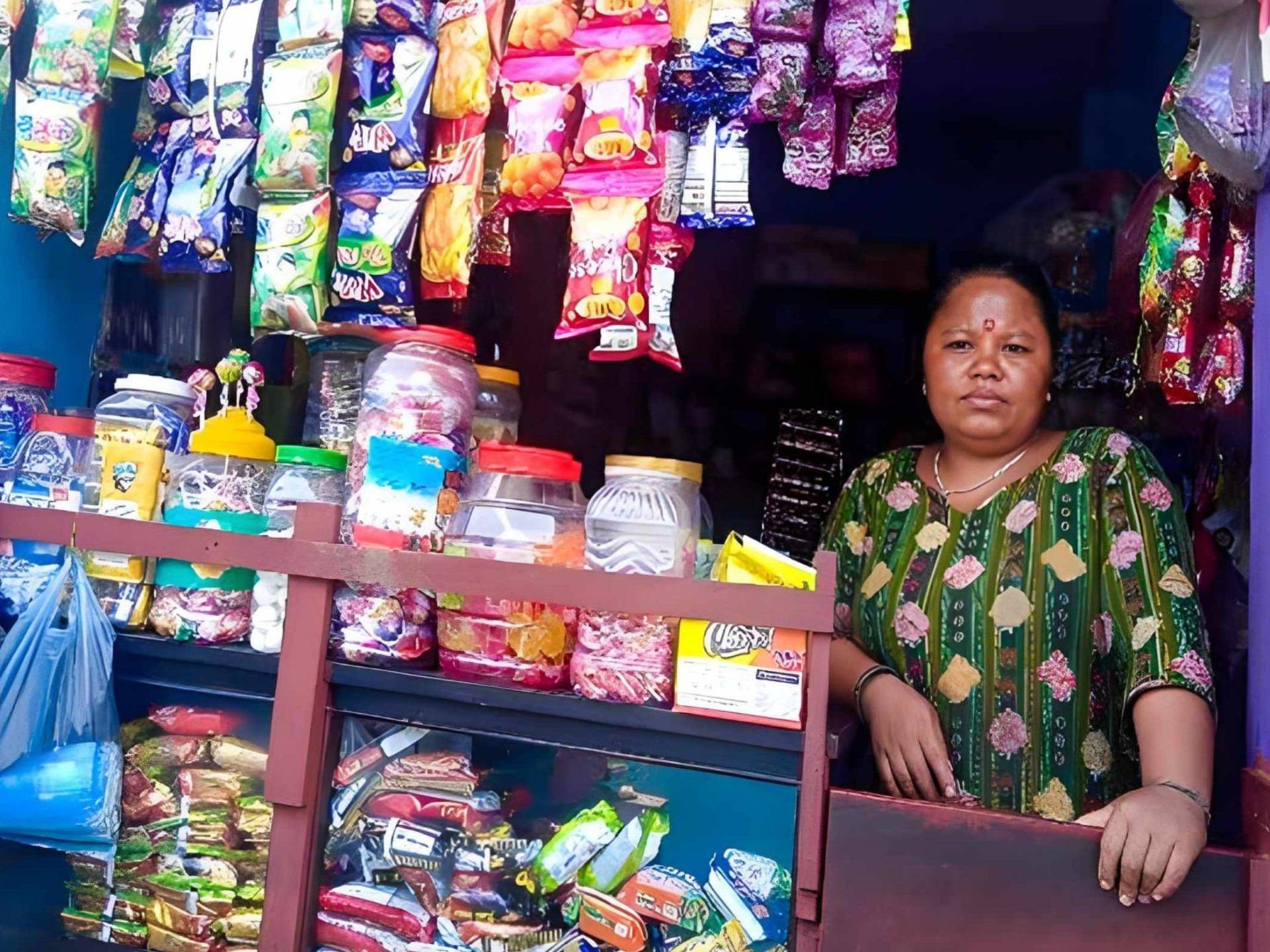 A woman poses in a snack shop, showcasing the colorful assortment of snacks available for purchase.