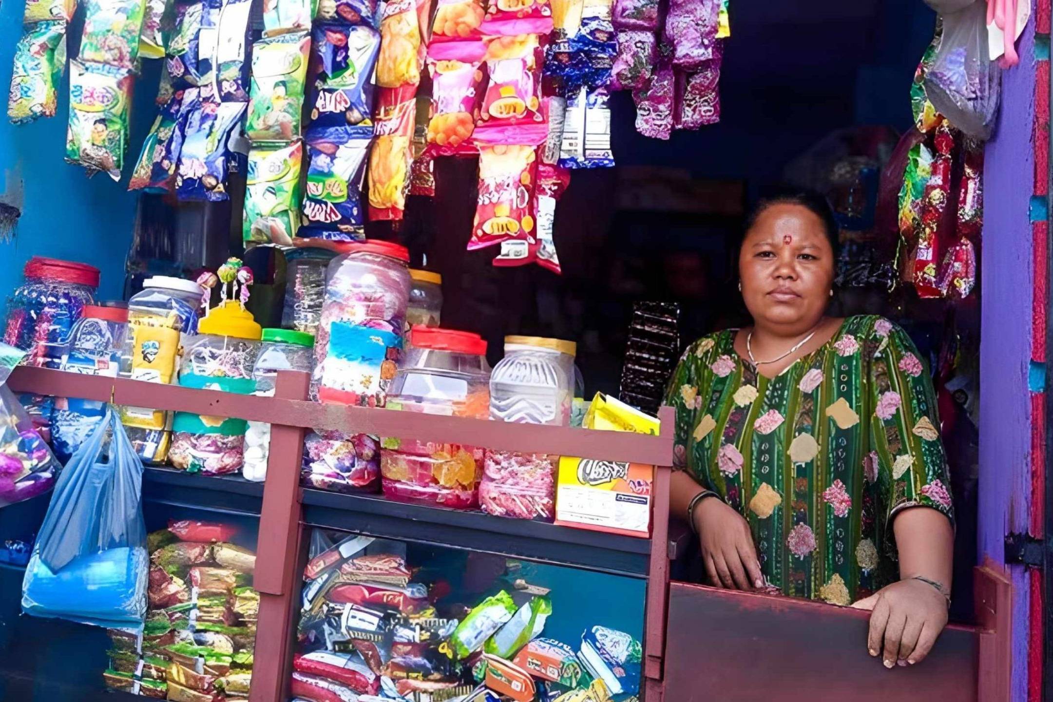 A woman poses in a snack shop, showcasing the colorful assortment of snacks available for purchase.