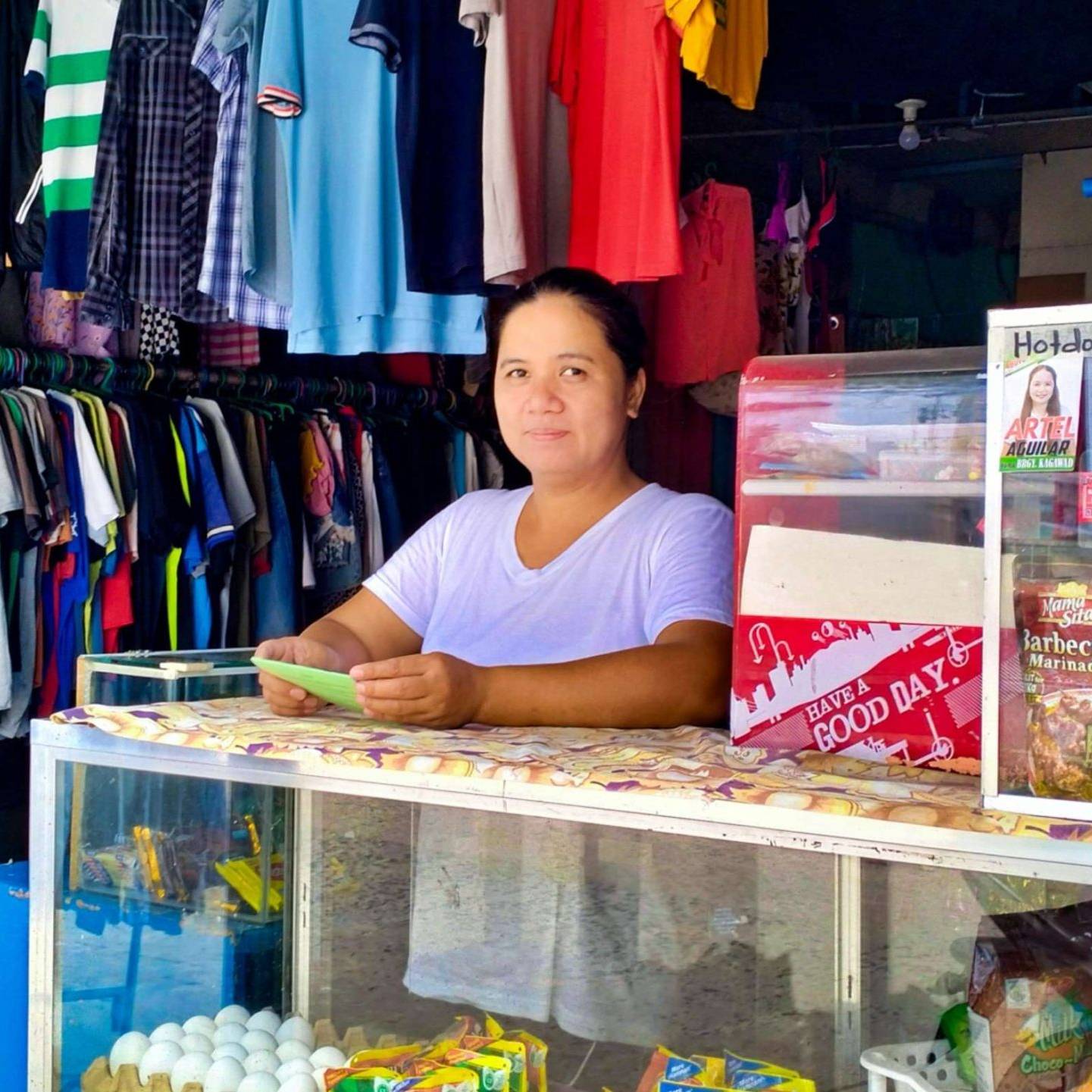 A woman standing at the counter of her variety store.
