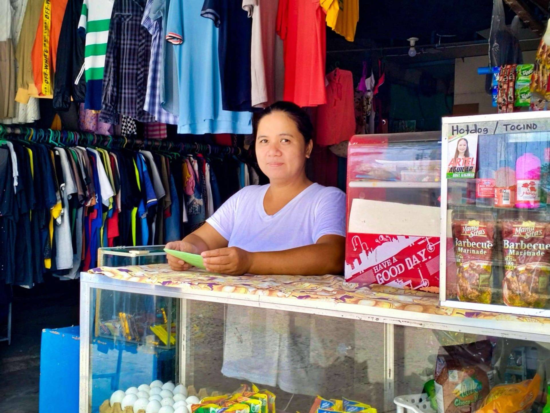 A woman standing at the counter of her variety store.