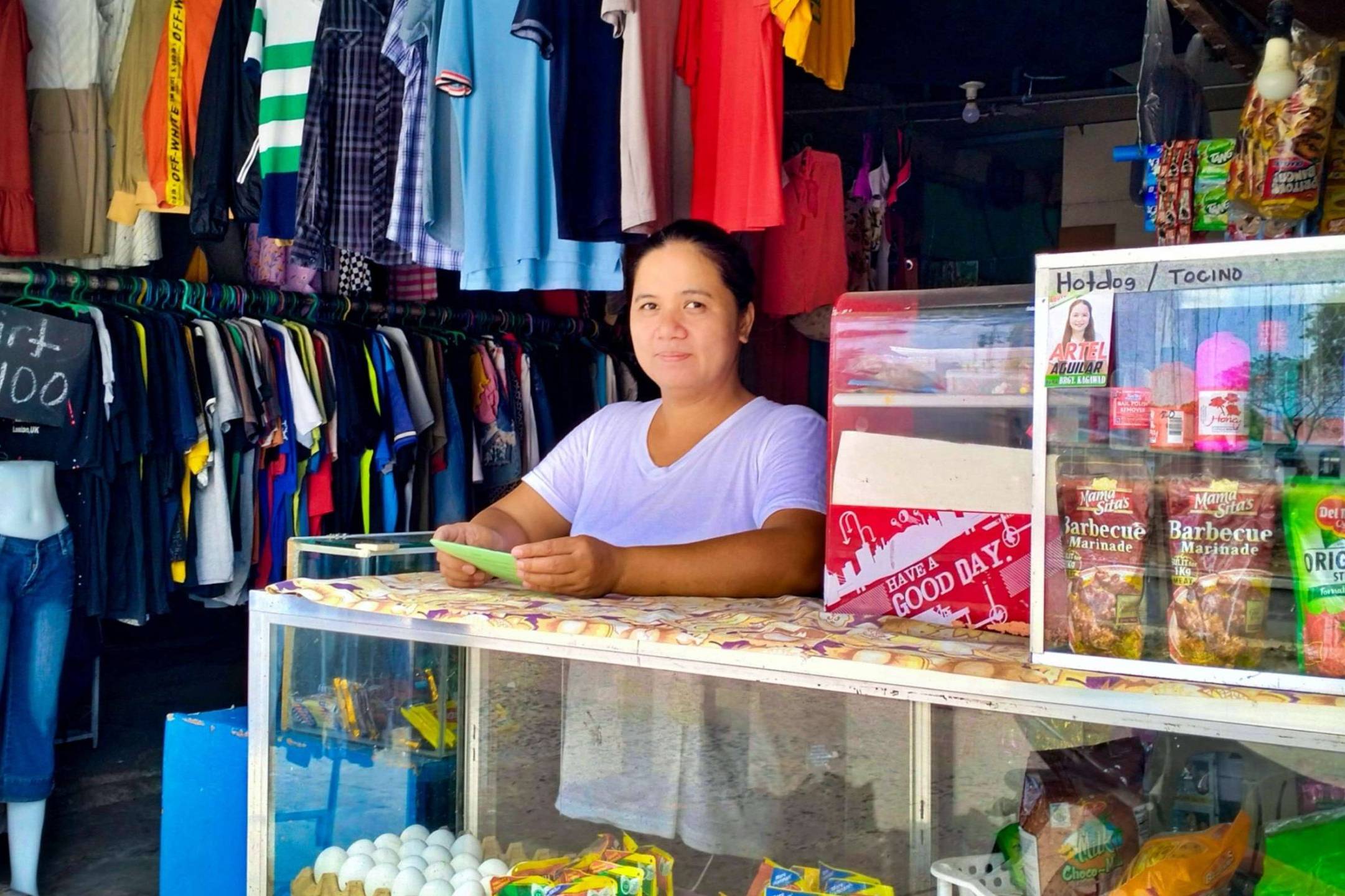 A woman standing at the counter of her variety store.
