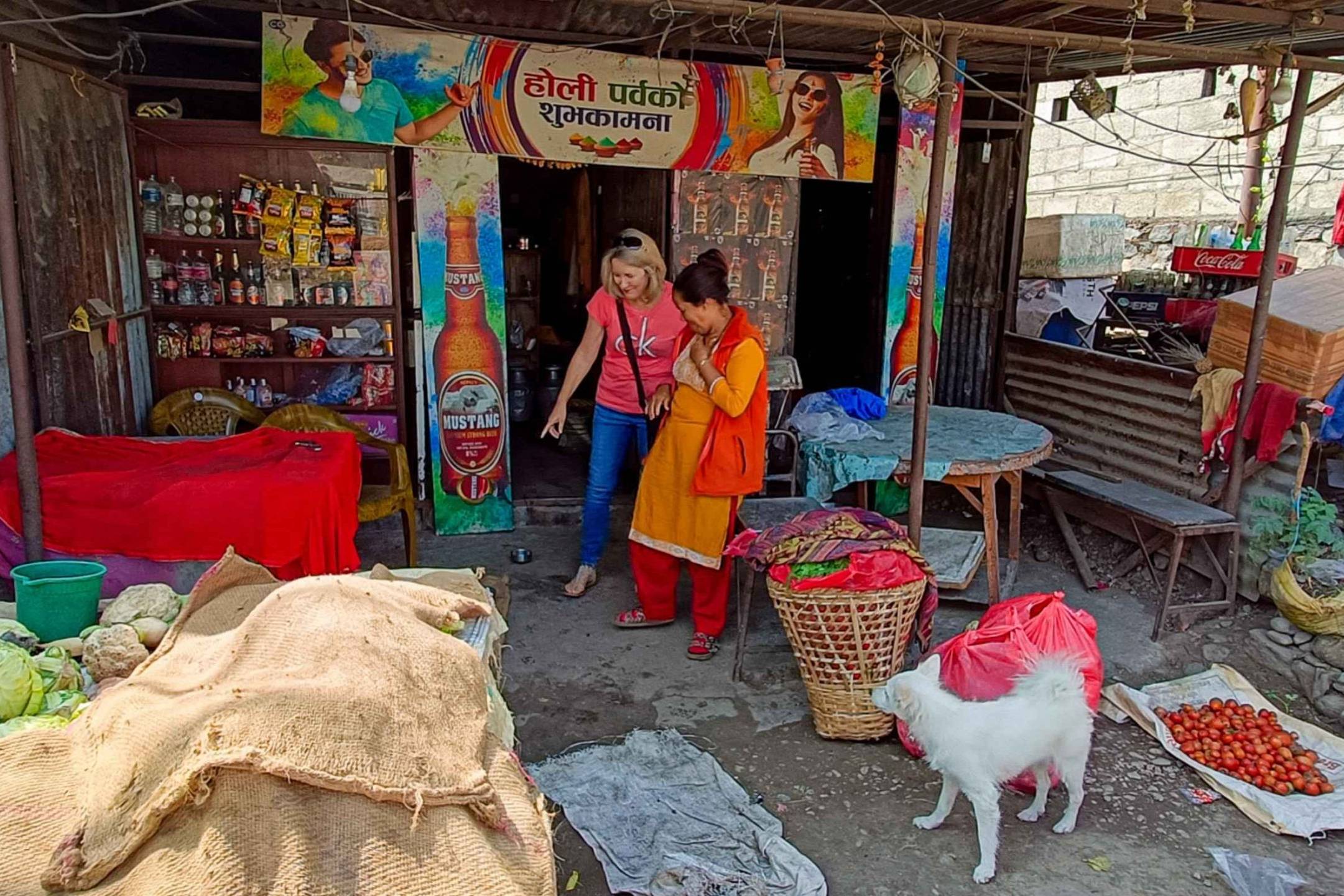 Two women and a dog are positioned outside a quaint shop, creating a friendly and inviting scene.