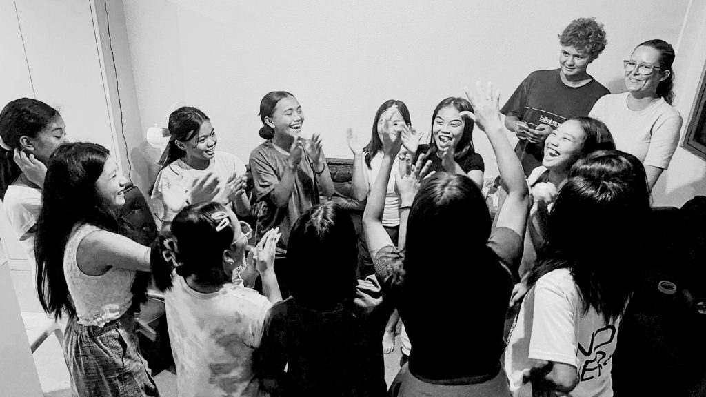 A group of joyful girls gathered around in a circle.