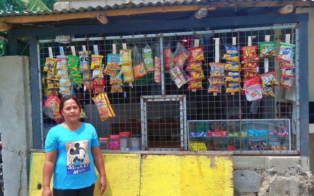 Woman stands in front of a small store